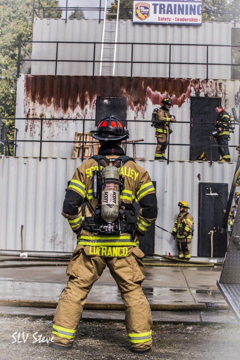 Scotts Valley Firefighter dressed in turnouts supervising other firefighters train